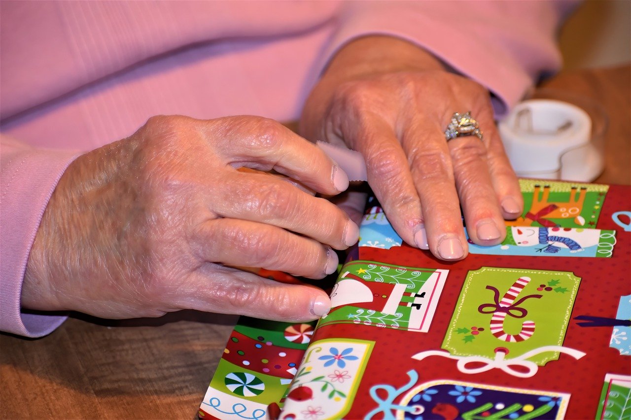 A photo of a woman's hands wrapping a Christmas present.