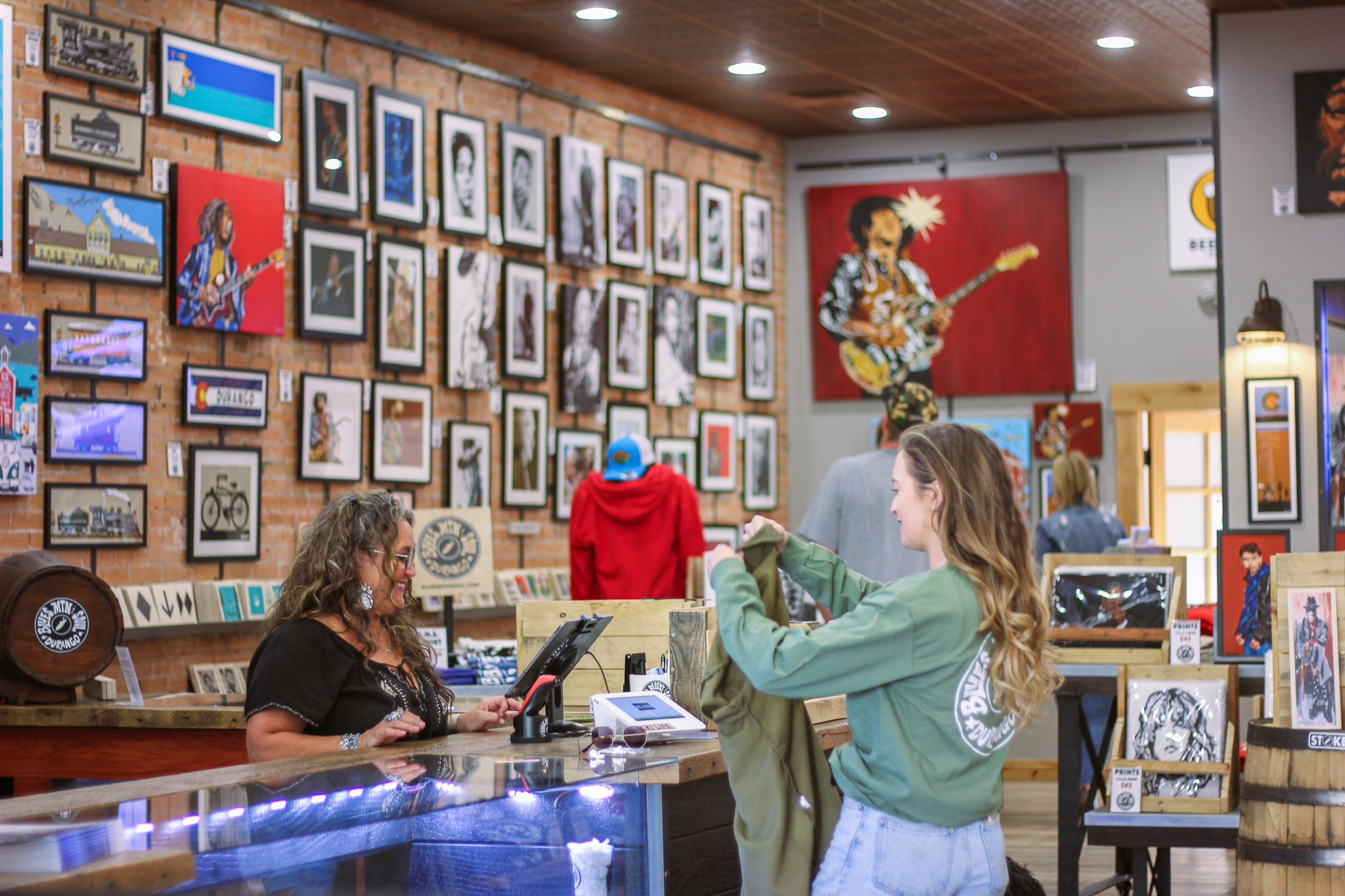 Person checking out a t-shirt at a shop counter.