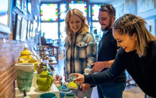 Three people looking at an object in a store.