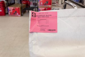 For the Birds Durango White bag in hardware store with a red tag reading "For the Birds" bird seed.