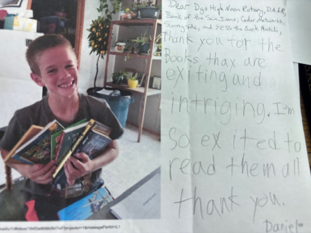A photo of a boy holding books next to a handwritten thank you note.