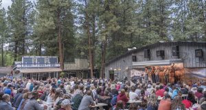 Bar D Chuckwagon People sitting at picnic tables watching a western concert.
